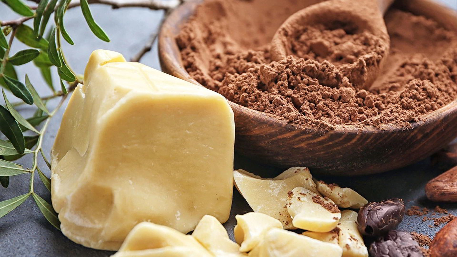 Kakaový prášok v drevenej miske a kakaové maslo